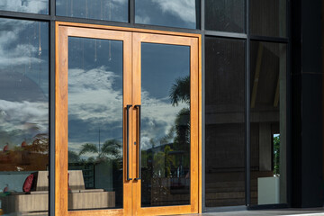 Glass door entrance to a large apartment hotel, the material is wood and steel, beautifully decorated.