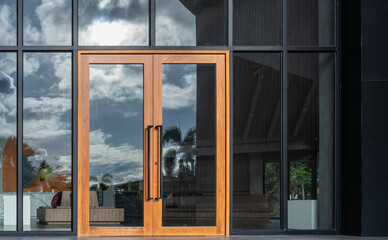 Glass door entrance to a large apartment hotel, the material is wood and steel, beautifully...