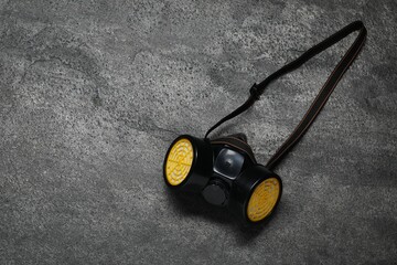 One respirator mask on grey table, top view. Space for text