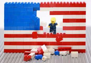 Obraz premium Hong Kong - July 1 2024: decent office man break the brick wall of usa flag