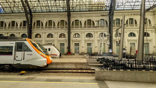 Barcelona's historic train station showcases its grand architecture with modern RENFE trains, symbolizing Spanish transport connectivity in spring, April 15, 2024