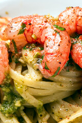 Deliziose linguine condite con pesto e gamberi rossi di mazara del vallo, pasta italiana, cibo mediterraneo 