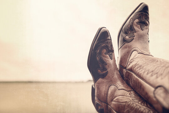 Cowboy boots with feet up resting and legs crossed