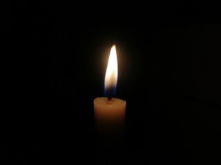 The Flame of a Candle Isolated in The Middle of a Dark Background