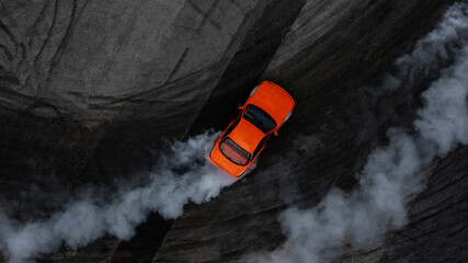 Aerial top view car drifting diffusion race drift car with lots of smoke from burning tires on...