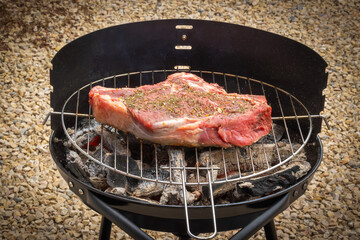 côte de boeuf crue, en gros plan, sur un barbecue	