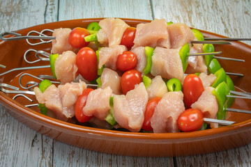 brochettes de poulet crus, en gros plan, dans un plat	