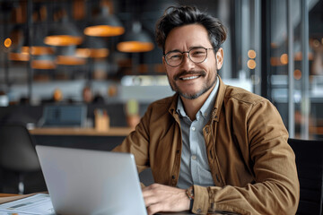 Obraz premium Professional Businessman Using Laptop in Modern Office, Financial Director or Analyst Looking Confident and Smiling at Camera