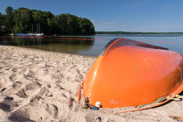 SWIMMING BEACH BY THE LAKE - Rowing water rescue boat on the sand
