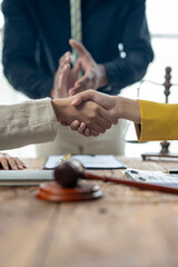 A man shakes hands with another man in a yellow jacket