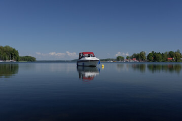 LANDSCAPE BY THE LAKE - Recreational motor yacht against the blue sky
