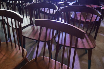 Antique chairs are arranged irregularly with lighting from behind.