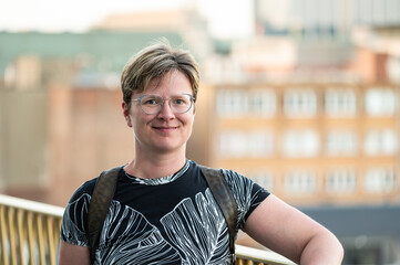 Outdoor portrait of a 38 yo white woman on a rooftop with old town in the background, Brussels, Belgium