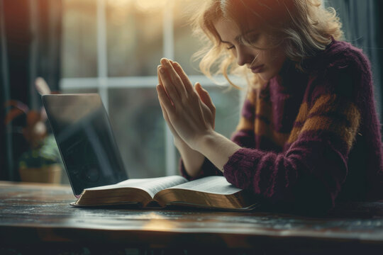 Woman Praying with Bible and Laptop on Table Religious Devotion and Reflection