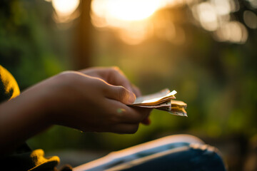 Close Up of Hands Counting Money Outdoors at Sunset with Natural Light