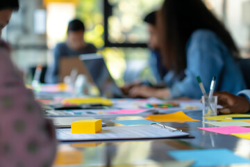 Fototapeta premium Colleagues Collaborating in a Modern Office with Colorful Sticky Notes and Documents