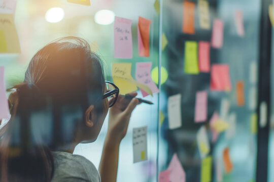 Productive Brainstorming Session with Colorful Sticky Notes on Glass Wall in Modern Office