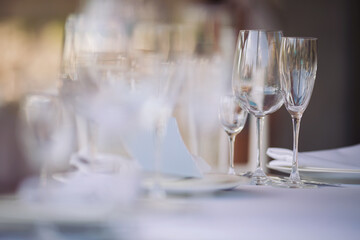 Beautiful table setting with crockery  for a party, wedding reception or other festive event. Glassware and cutlery for catered event dinner. Beautiful table set for some festive event