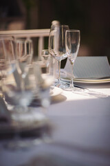Beautiful table setting with crockery  for a party, wedding reception or other festive event. Glassware and cutlery for catered event dinner. Beautiful table set for some festive event