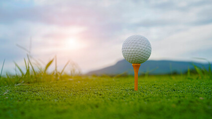 golf ball on tee in beautiful golf course with sunset. Golf ball close up in golf coures.