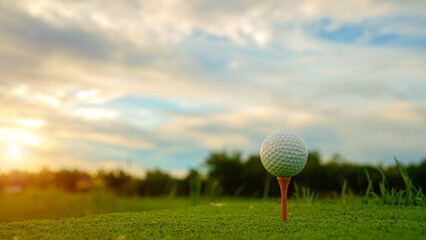 golf ball on tee in beautiful golf course with sunset. Golf ball close up in golf coures.