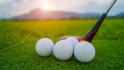 Golf ball on green grass in the evening golf course with sunshine background.