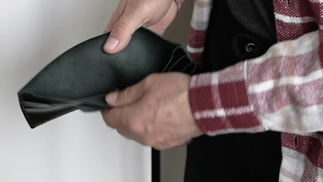 Ederly man with an empty wallet without money. Crisis in people, financial problems in an old person. Bankrupt man