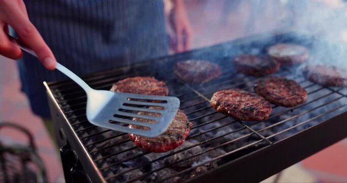 Hands, burger and bbq dinner for party, meat and outdoor backyard cooking. Flames, food and smoke for barbecue, bonding and relax grill with traditional American culture for Independence day