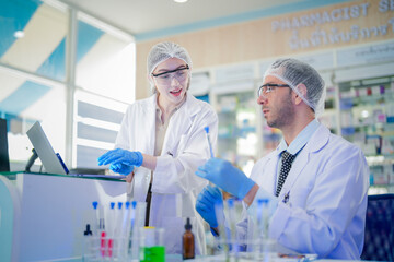 Fototapeta premium scientists perform experiments and record data. people arranges equipment with test tubes and chemicals for producing medicine and biochemistry. man hold tubes of chemical liquids and plant samples.
