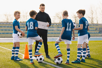 Football tactics training for children. Boys with a coach on the football field. Coach talking...