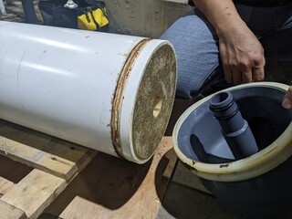 Inspection Water Ultra Filtration Membrane skid Maintenance. A close-up view of a water filter cylinder, featuring a white outer layer and a gray inner tube.