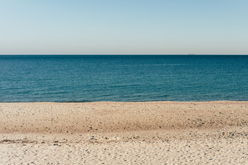 A beach with a clear blue ocean and a sandy shore