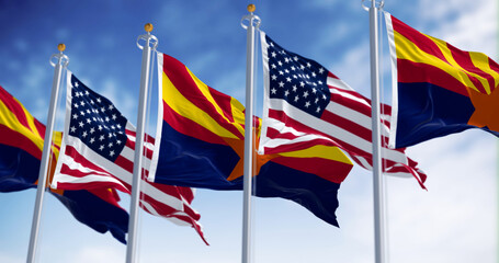 Flags of Arizona and United States waving in the wind on a clear day
