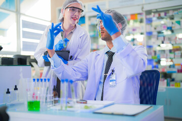 Fototapeta premium scientists perform experiments and record data. people arranges equipment with test tubes and chemicals for producing medicine and biochemistry. man hold tubes of chemical liquids and plant samples.