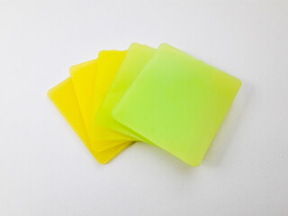 stack of graded yellow and green color chips, isolated on a white background. This is an example of...