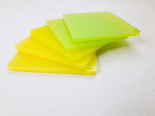 stack of graded yellow and green color chips, isolated on a white background. This is an example of the color produced by masterbatch in plastic products