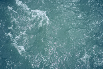 Waves and ripples in the sea close-up. The water is blue in color with a place to copy. Raging waters. Ripples and waves on the water. High quality photo