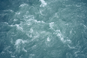 Ripples on the water from a wave. Background with a liquid texture.Ripples on the liquid with a bubbling effect and bubbles with space to copy. High quality photo