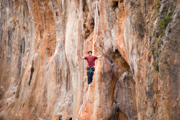 A tightrope walker balances on a rope over an abyss.