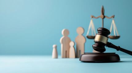 Wooden gavel and scale of justice with wooden figures representing a family against a blue background, symbolizing family law, human rights and justice.
