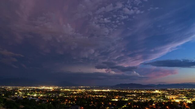 Timelapse of storm moving over Utah Valley as lightning flashes at dusk overlooking Provo.