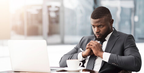 Coronacrisis And Bankruptcy. Thoughtful Black Businessman Sitting At Laptop Thinking How To Save...