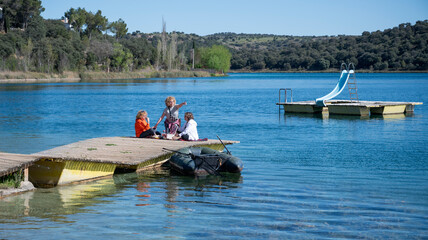 Middle-aged sisters having a picnic by the lagoon in nature on a sunny day.