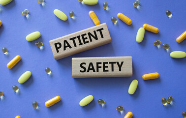 Patient Safety symbol. Concept word Patient Safety on wooden blocks. Beautiful purple background with pills. Medicine and Patient Safety concept. Copy space