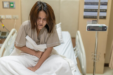 Fototapeta premium Asian woman is sick and is being treated at the hospital,Waiting for the doctor to give intravenous medication,A nurse came to take my temperature and measure my blood pressure.