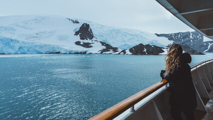 Antarctica Cruise Passenger Views Glacier. Beautiful Girl Hair Blowing in Wind on Side Railing Tour...