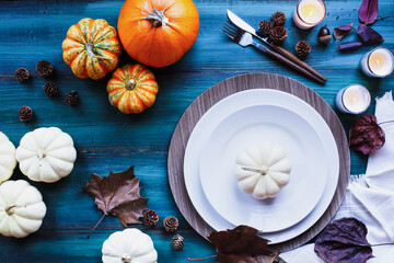 A holiday place setting with place setting on a colorful Thanksgiving Day decorated table shot from...