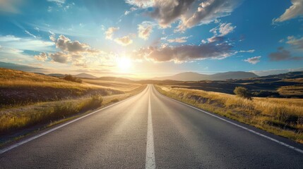 Fototapeta premium Open road sunset landscape. Scenic view of an empty asphalt road leading towards a beautiful sunset over rolling hills and golden fields.