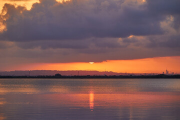 Wonderful view of the setting sun behind gray clouds