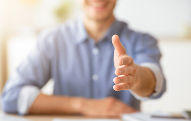 Handshake Gesture. Smiling Man Stretching Hand For Greeting Sitting At Home. Shallow Depth, Cropped